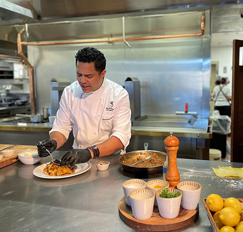 Male chef hosting a cooking demo in a kitchen