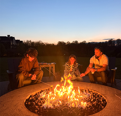 family enjoys smores by the firepit