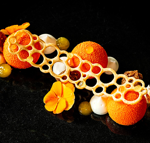 Bright orange Yuzu dessert with edible orange flowers