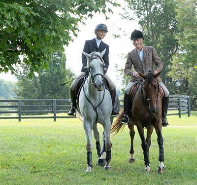 Couple riding horses in partial jockey gear
