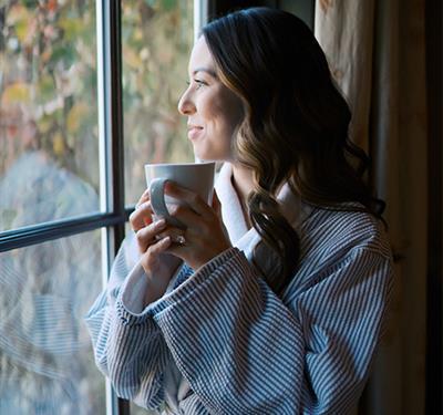 woman in spa robe relaxes with cup of tea